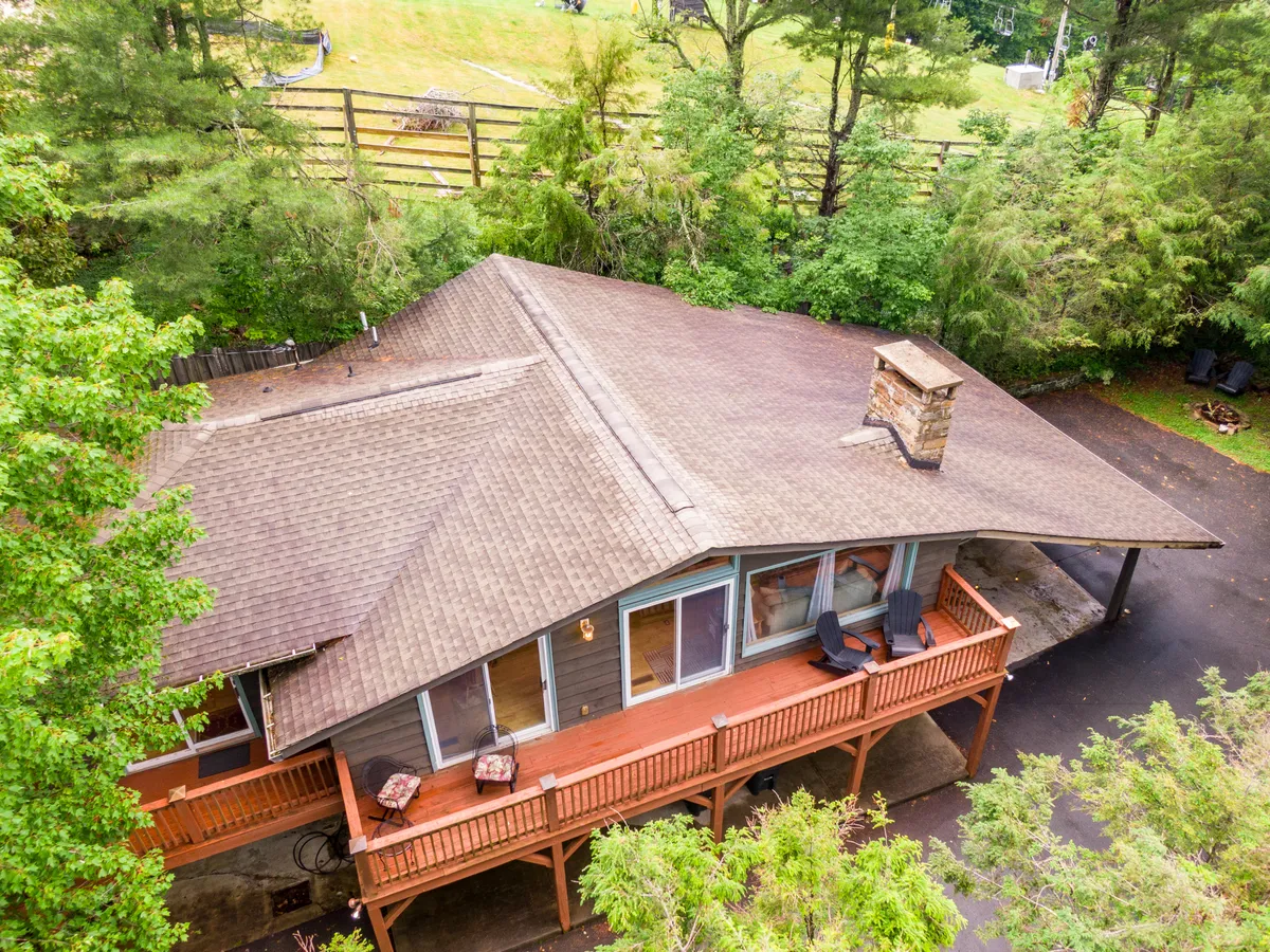 This exterior image captures a spacious wooden deck with a comfortable seating area and surrounding greenery. The deck looks ideal for lounging, reading, or hosting outdoor gatherings, with a tranquil, inviting vibe that highlights the connection to nature and ample space for both people and pets.