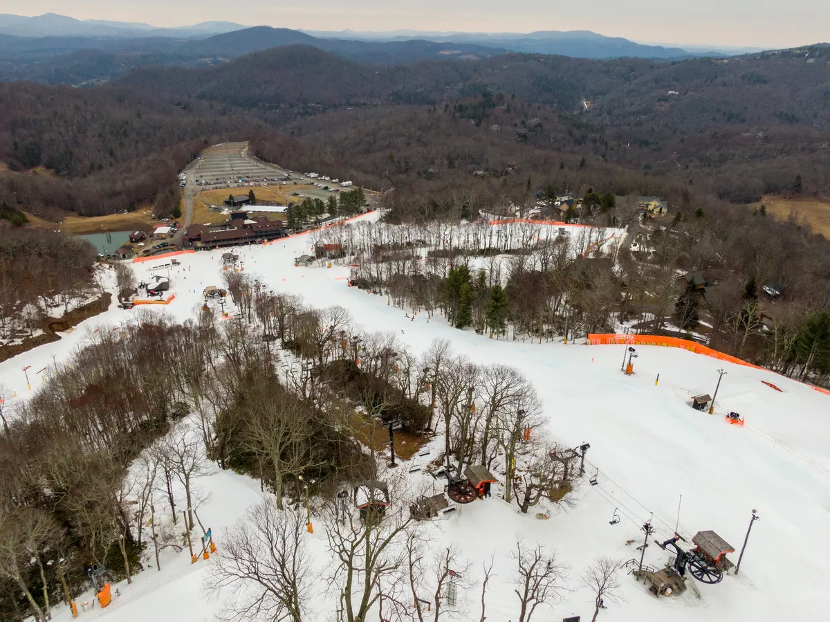 A panoramic exterior view showcasing ski slopes, chair lifts, and surrounding snow-covered mountains. The scene is filled with adventure, energy, and the possibility for friends and families to create memories together.